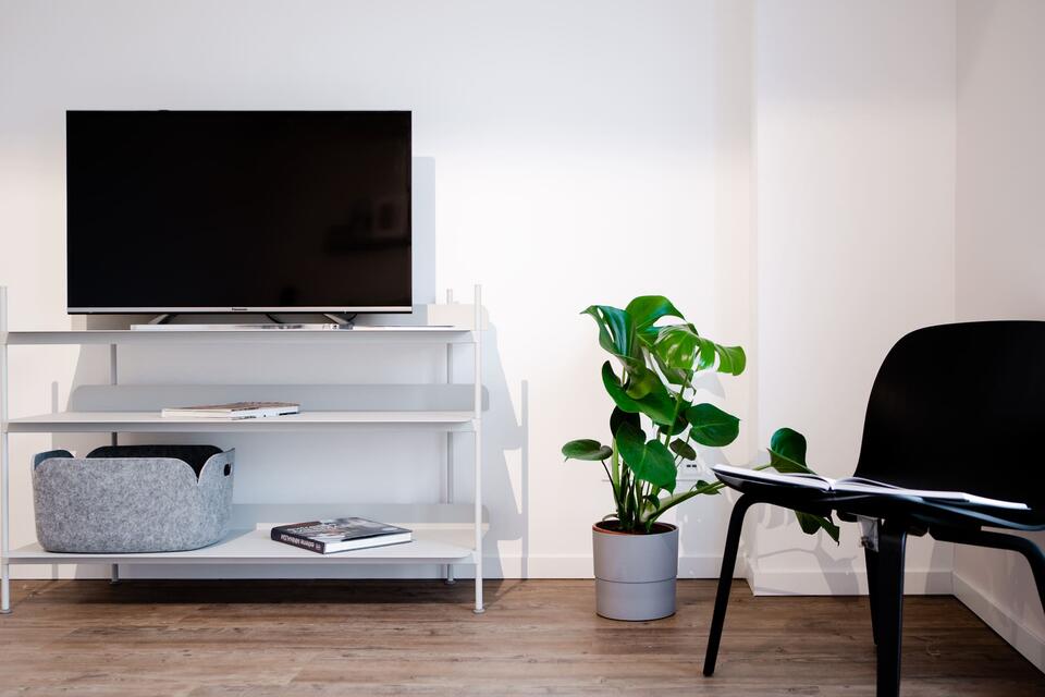 Wood plank flooring TV stands with black chair